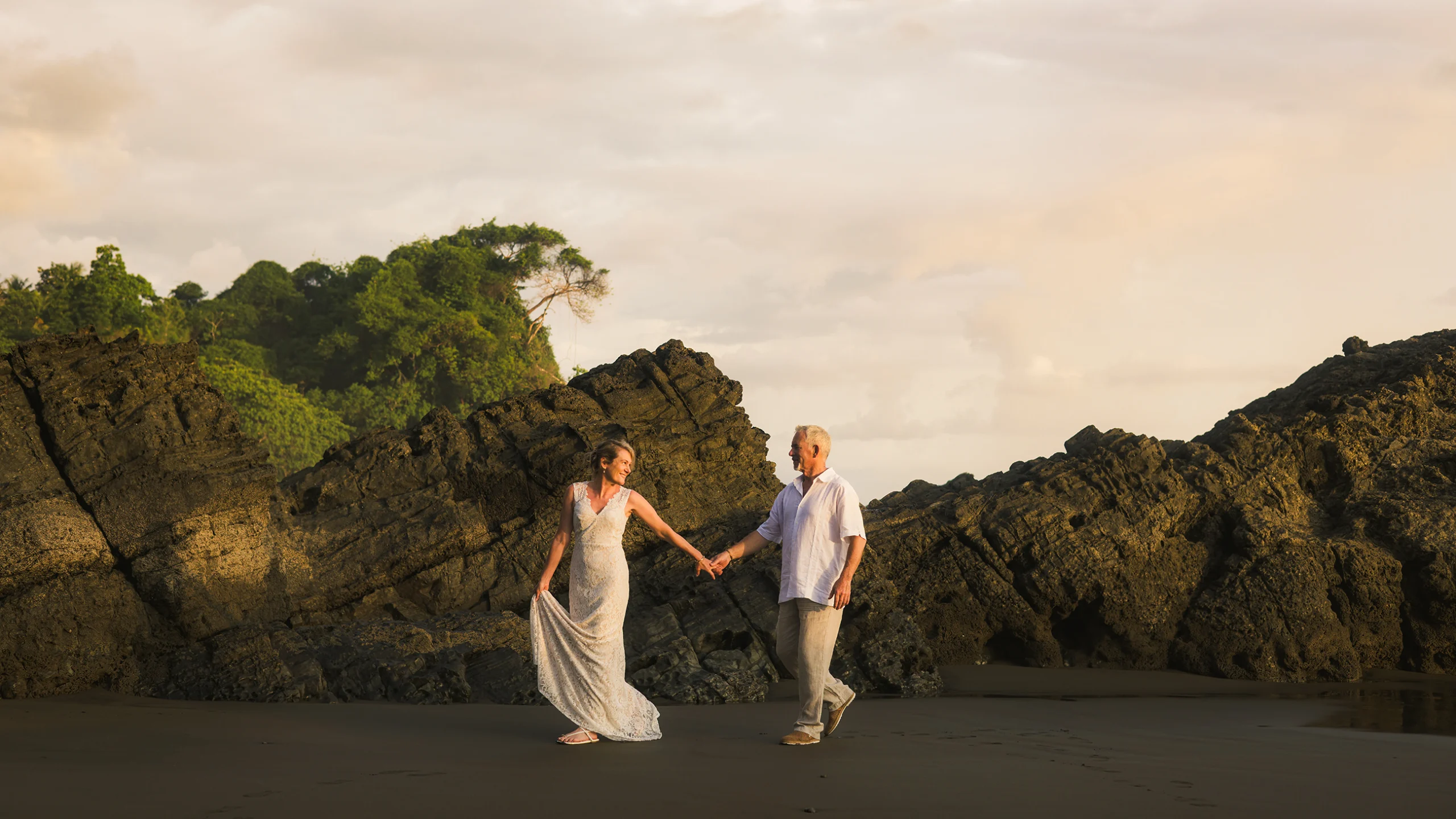 Couple walking hand in hand during a sunset beach photoshoot in Uvita, Costa Rica