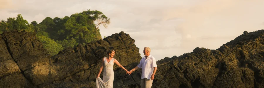 Couple walking hand in hand during a sunset beach photoshoot in Uvita, Costa Rica